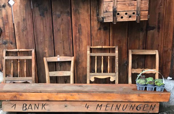 Martina Wendinger | Denklingen - Systemische Familienberatung - das Bild zeigt vier Holzstühle hinter einer Holzbank, im Hintergrund ist eine Holzhütte zu sehen